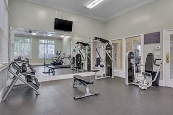 A spacious gym with a variety of equipment including treadmills, weights, and exercise machines.